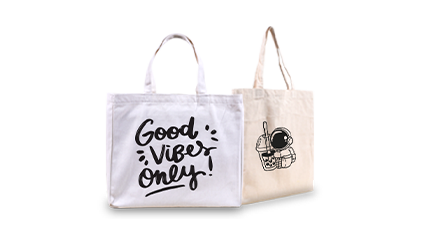 A pair of tote bags are displayed side-by-side, one says 