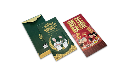 Money packets (ang pows) placed side by side, featuring designs for Hari Raya and Chinese New Year.