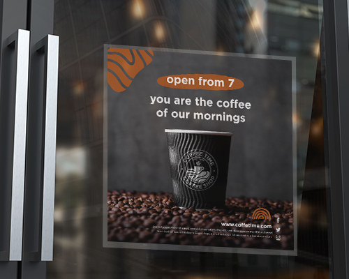 A static cling window sticker is placed on the door, printed with a design in black stating 'open from 7' with illustrations of coffee beans and paper cup.