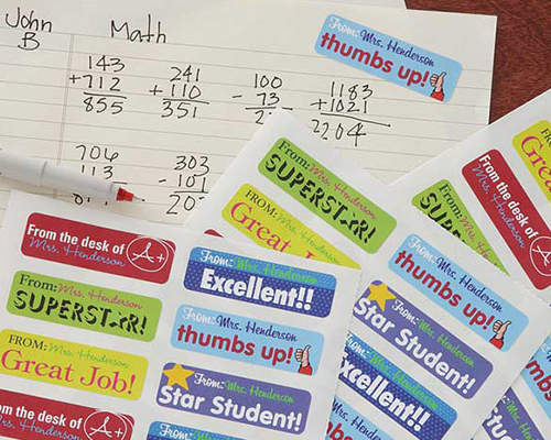Three pieces of multiple dieline stickers are placed on a maths exercise book, printed with encouraging phrases.