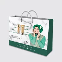 A paper bag for the beauty products with a woman in green, white, gold and grey.