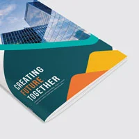 A creating future together booklet with saddle stitching in green, yellow, orange and a building picture on cover.