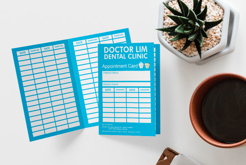 A patient appointment card for Doctor Lim Dental Clinic sitting on a white table next to a succulent and a cup of coffee.