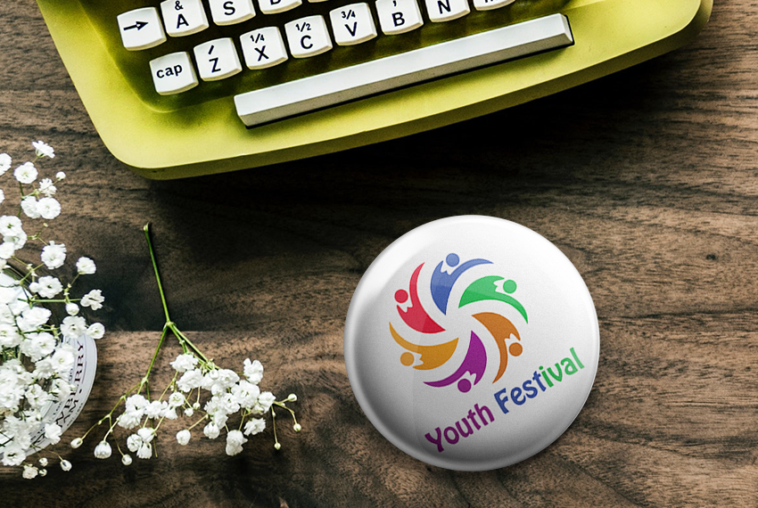 White button badge with a stylized logo of 6 people in a circle in 6 different colours, with a label stating “Youth Festival” underneath.