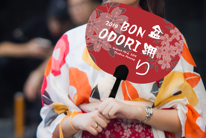 A woman in a kimono holds a simple red hand fan advertising a “2019 Bon Odori”.