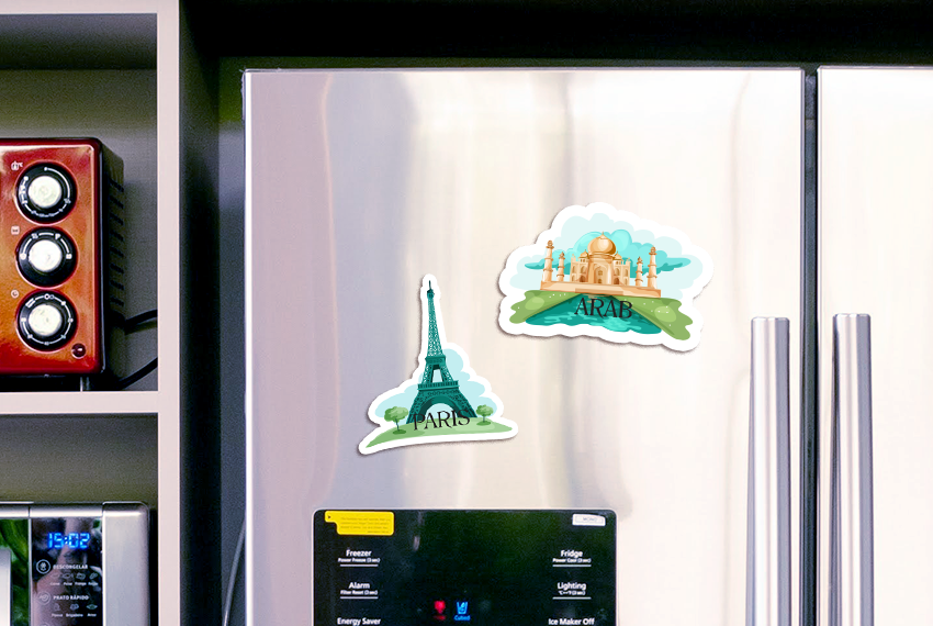 Two custom die cut magnets, one featuring the Eiffel Tower, one featuring the Taj Mahal, arranged side by side on a silver refrigerator door.