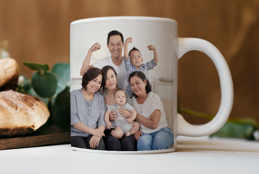 A white mug printed with the image of a family sits on a table.