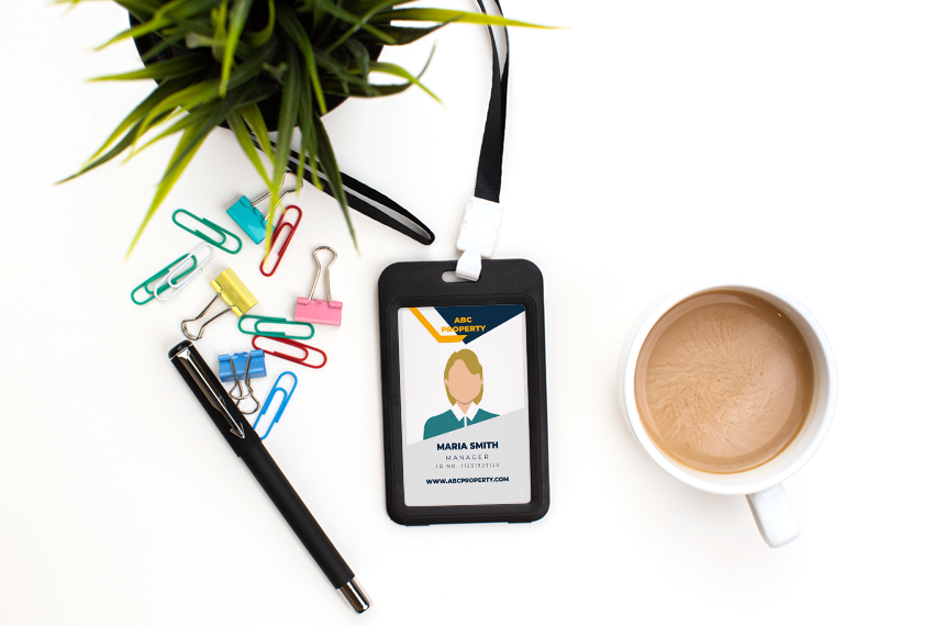 A card sits in a lanyard surrounded by stationery and coffee.