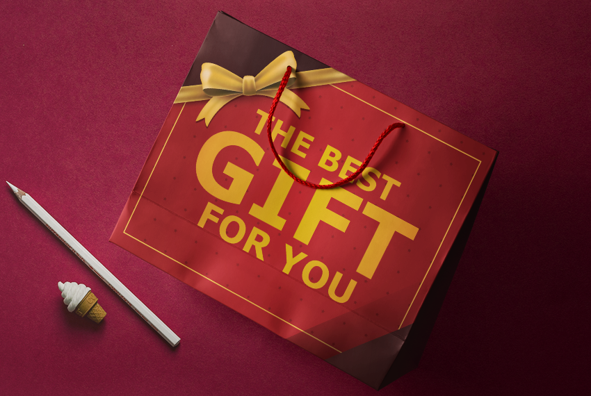 A flattened paper bag printed with “The best gift for you” rests on a red background.