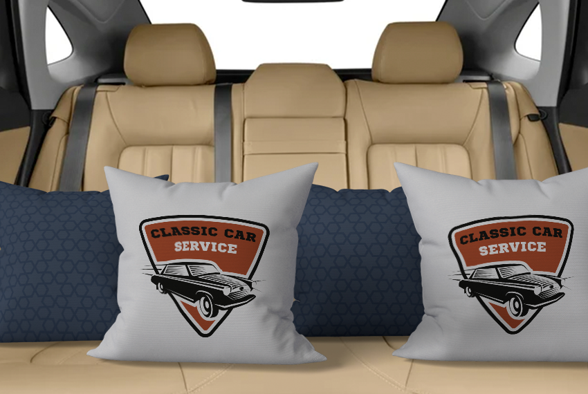 Pillows printed with a car logo are piled in the back seat of a car.