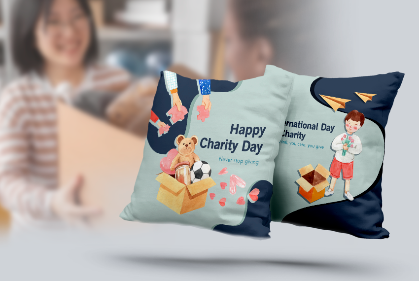 Two pillows that say “Happy Charity Day” flow against a blurry background of a woman accepting a box.