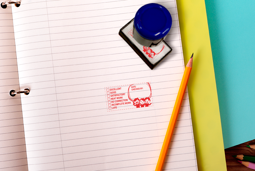 A rubber stamp with a blue handle sits on a notebook next to a fresh stamp.