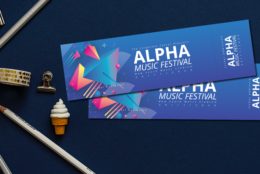 Two tickets to a music festival are arranged next to several pieces of stationery.